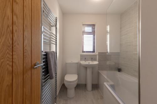 Orchard House - 2 bedroom house, Central Alnwick في ألنويك: حمام مع مرحاض ومغسلة وحوض استحمام