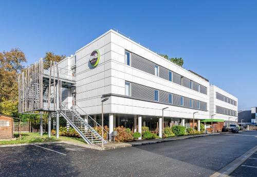 a white building with a spiral staircase in front of it at B&B HOTEL Bordeaux Langon in Langon