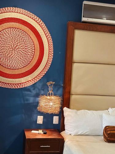 a bedroom with a bed and a hat on the wall at Suites Valentina in Puerto Morelos
