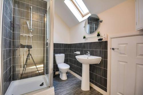 a bathroom with a toilet and a sink and a shower at Lovely 3 Bed House in Runcorn in Runcorn