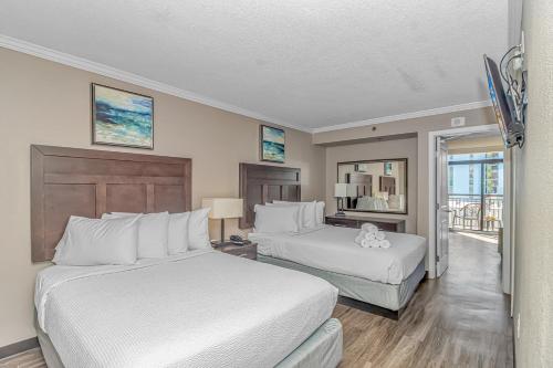 默特尔比奇Immaculate Ocean View Suite!-Caravelle Resort 1004-Sleeps 6 Guests!的有两张床和一个阳台的酒店房间