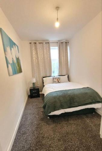 a bedroom with a large bed and a window at 4-Bed House in Accrington in Accrington