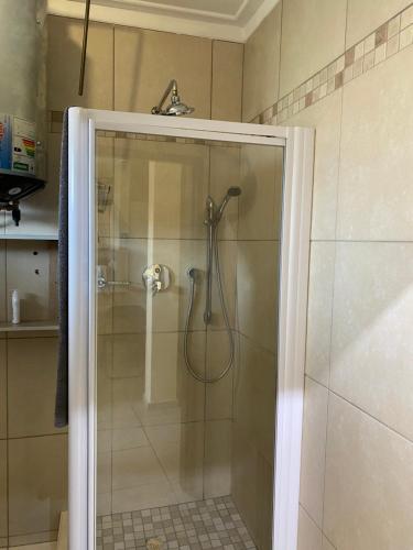 a shower with a glass door in a bathroom at Unit 11 - Damara Gardens in Windhoek