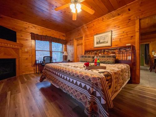 um quarto com uma cama num chalé de madeira em Spacious Resort Log Cabin, Easy Drive, Hot Tub, Arcade Gameroom, Mountain Vibe em Gatlinburg