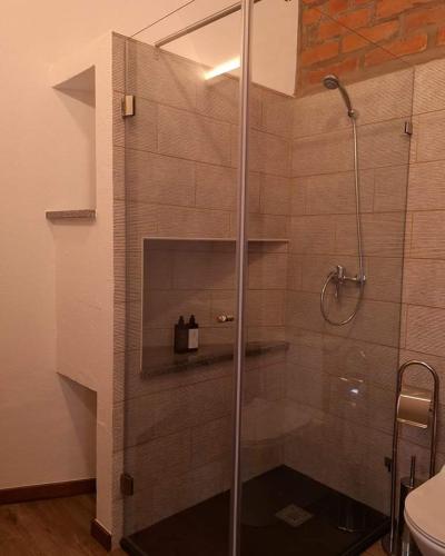 a shower with a glass door in a bathroom at Porta 28 in Penacova
