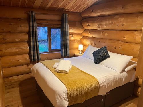 a bedroom with a bed in a log cabin at Mountain Edge Resort in Church Stretton