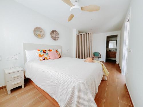 a bedroom with a white bed and a ceiling fan at Femina Blue in Cambrils