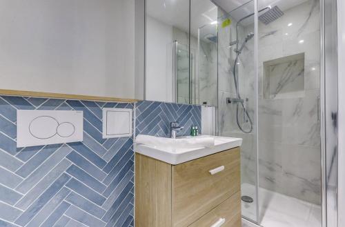 une salle de bain avec un lavabo et une douche dans l'établissement La Nuit Etoilée - Moderne & Elégant - Marais, à Paris