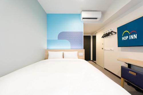 - une chambre avec un grand lit et un bureau dans l'établissement Hop Inn Tokyo Asakusa, à Tokyo