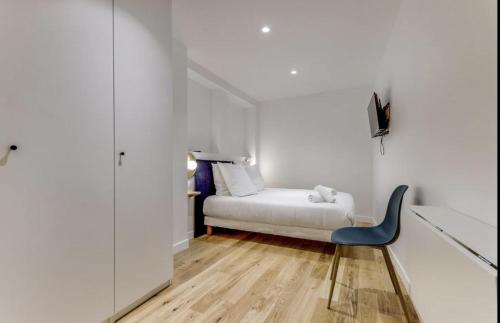 - un salon avec un canapé blanc et une chaise bleue dans l'établissement La Nuit Etoilée - Moderne & Elégant - Marais, à Paris