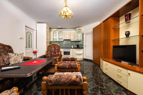 a living room with a dining room table and a kitchen at A Nostalgic Getaway in Plovdiv's Historic Quarter in Plovdiv