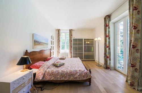 a bedroom with a large bed and some windows at Château Monts Blancs in Lumbin