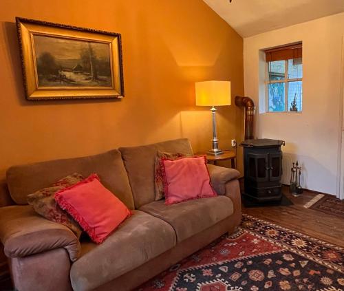 a living room with a couch and a wood stove at Hoeve de Knol in Holthees