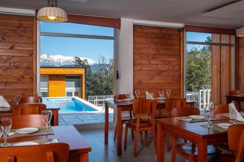 um restaurante com mesa e cadeiras e uma piscina em Bahía Montaña Resort em Villa La Angostura