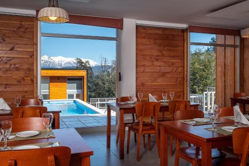 a restaurant with a table and chairs and a swimming pool at Bahía Montaña Resort in Villa La Angostura