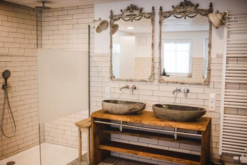 a bathroom with two sinks and a mirror at Ferienhof Greuthof in Bad Wurzach
