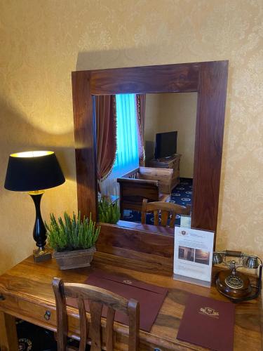 a mirror on top of a wooden desk with a room at Hotel Zameczek in Książ Wielki