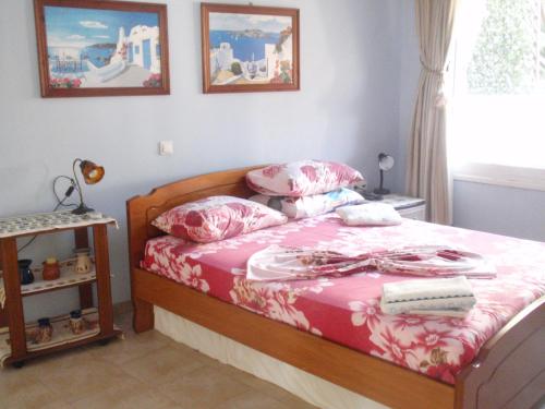 sypialnia z łóżkiem z różową pościelą i poduszkami w obiekcie Traditional apartment w mieście Kalimnos