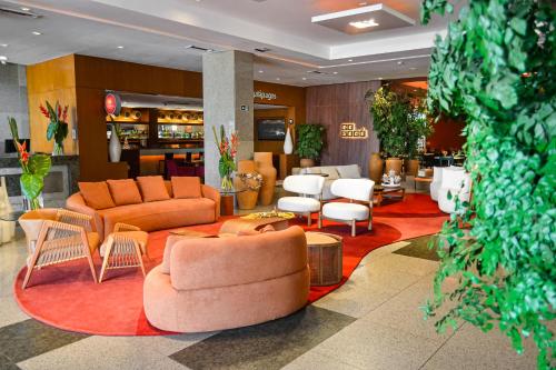 un vestíbulo con sofás y sillas en un edificio en Seara Praia Hotel, en Fortaleza
