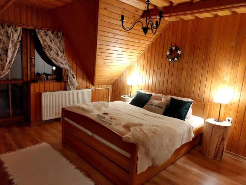 ein Schlafzimmer mit einem großen Bett in einem Holzzimmer in der Unterkunft Chata Drevenica in Habovka