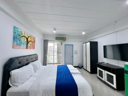 ein Schlafzimmer mit einem großen Bett und einem Flachbild-TV in der Unterkunft The Sceneสุพรรณบุรี in Suphan Buri