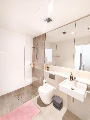 a white bathroom with a toilet and a sink at Cozy Apartment at St Leonard in Sydney