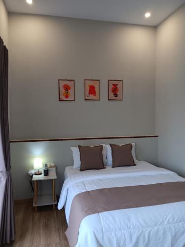 a bedroom with two beds and a table with a lamp at 44 Guest House Syariah in Purwokerto