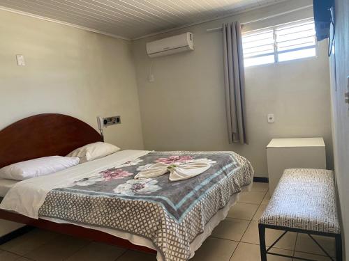 een slaapkamer met een bed en een raam bij Hotel Pousada em frente ao Nações Shopping in Criciúma