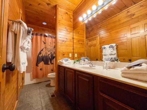 uma casa de banho com um lavatório e um WC numa cabina em Spacious Resort Log Cabin, Easy Drive, Hot Tub, Arcade Gameroom, Mountain Vibe em Gatlinburg