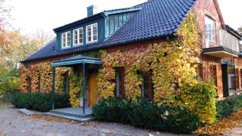 特雷勒堡的住宿－Minnesberg Bed & Breakfast，蓝色屋顶的常春藤房子