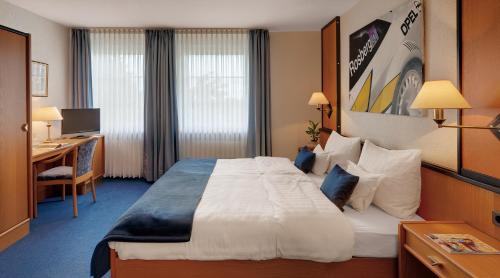 a hotel room with a large bed and a desk at Motorsport Hotel in Nürburg