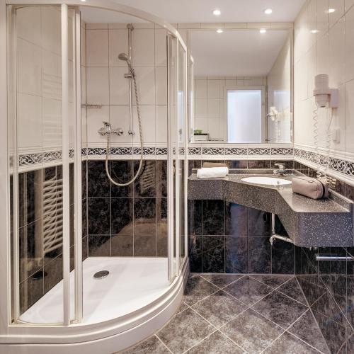 een badkamer met een douche en een wastafel bij Motorsport Hotel in Nürburg