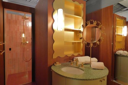 une salle de bain avec un lavabo et un miroir dans l'établissement Le Neptune - Splendide - Sauna - Saint-Germain, à Paris