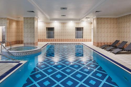 basen z niebieską podłogą wyłożoną kafelkami i wanną w obiekcie Leonardo Hotel Middlesbrough w mieście Middlesbrough