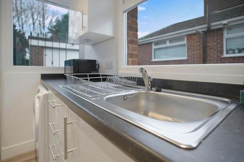 um balcão de cozinha com um lavatório e uma janela em Sleek & Tranquil Corner on Durham Road, Sleeps 4 em Lackenby