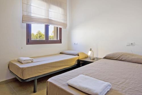 two beds in a room with a window at Villa Lia - PlusHolidays in Calpe