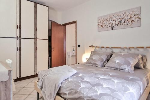 um quarto com uma cama grande e lençóis brancos em Casa Ninin - Belcanto Villas em Viareggio