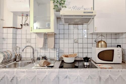 uma cozinha com um lavatório e um micro-ondas em Casa Ninin - Belcanto Villas em Viareggio