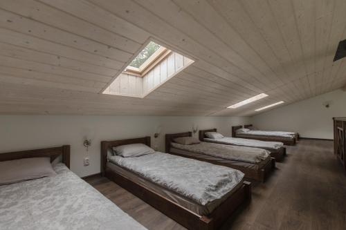 eine Reihe von Betten in einem Zimmer mit Fenster in der Unterkunft Holiday home Uzbazes in Valmiera