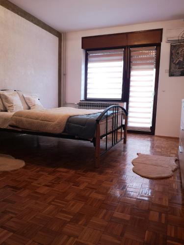 a bedroom with a bed and a wooden floor at Evergreen in Banja Luka