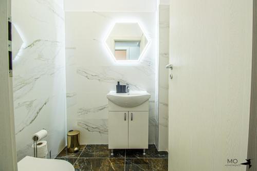Baño blanco con lavabo y espejo en MO Apartments Spac, en Brasov