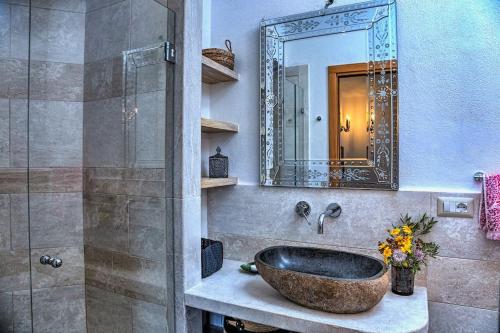 Un baño con un lavabo de piedra y un espejo. en Villa Luciana, en Cannigione