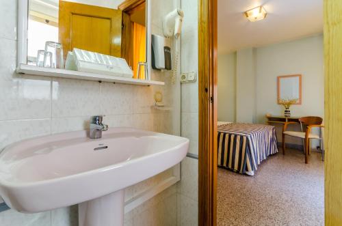 y baño con lavabo y espejo. en Hotel Mediterráneo, en Guardamar del Segura