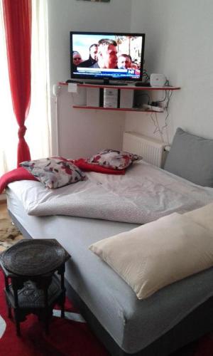 two beds in a room with a tv on the wall at Bjelasnica Mini Studio in Sarajevo