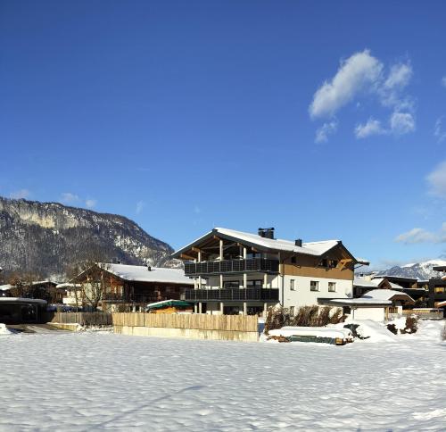 um edifício com neve no chão em frente em Ferienwohnung Ortner em Sankt Johann in Tirol
