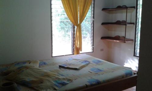 a bed in a room with a window at El Castillo Divertido in Paraíso