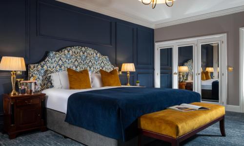 um quarto com uma cama king-size e paredes azuis em The Heritage em Killenard