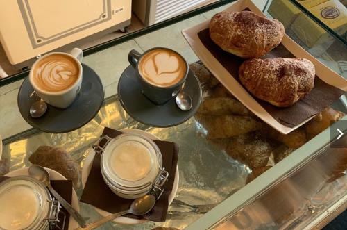 a glass table with two cups of coffee and pastries at Le residenze del capitano in Bari