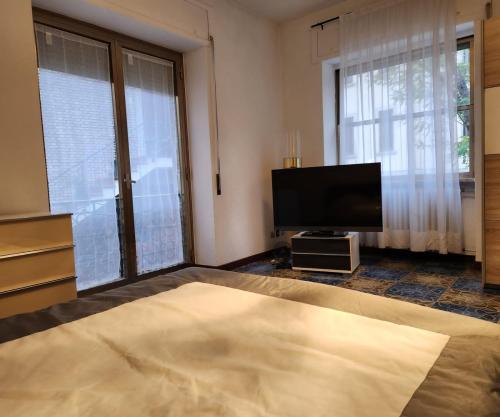uma sala de estar com uma televisão de ecrã plano e uma cama em La Famosa Dimora Ambasciatore em San Marino