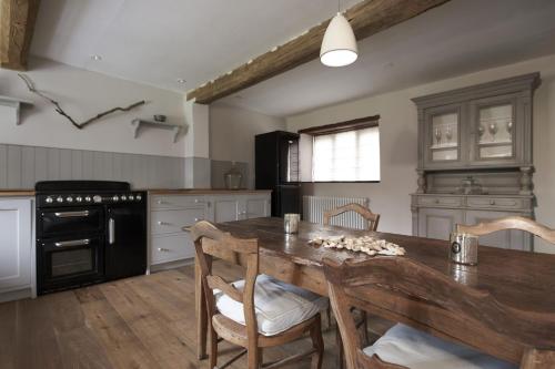 a kitchen with a wooden table and a dining room at Shell in Sharrington